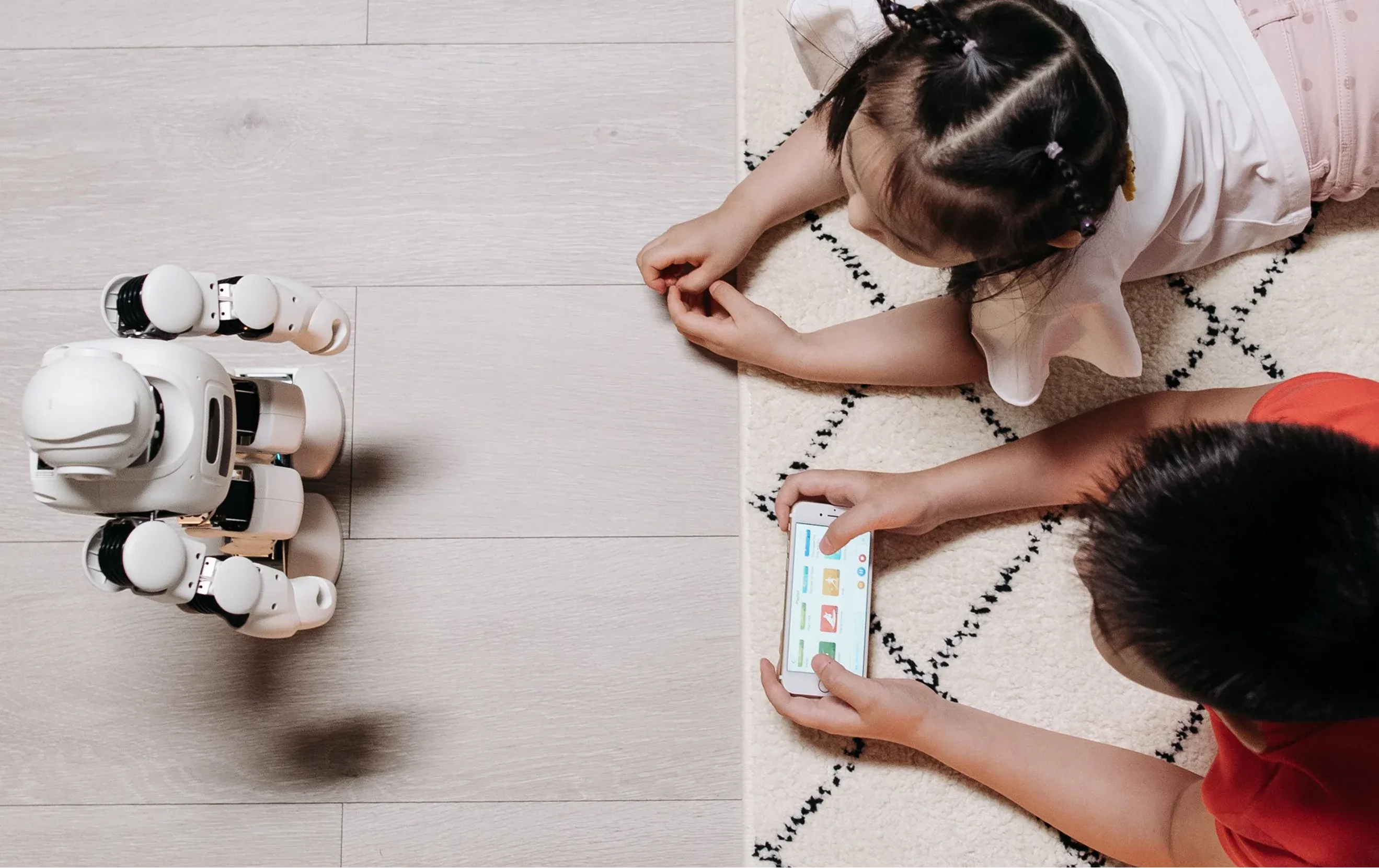 Two kids playing with an AI robot toy